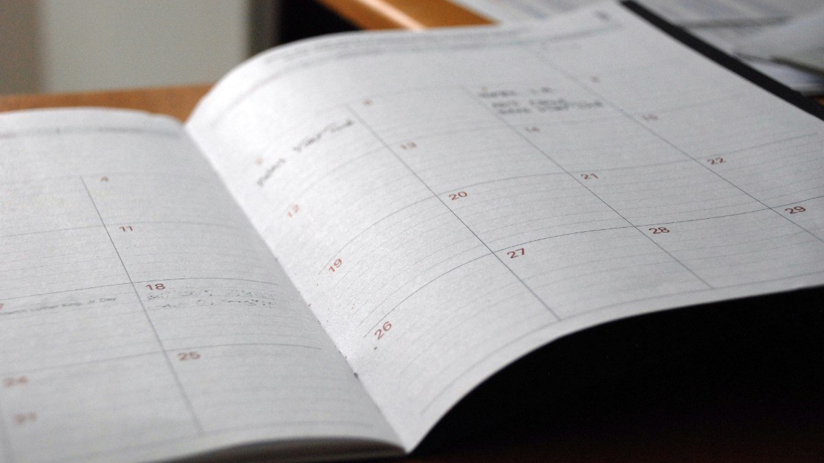 Agenda de papel aberta sobre a mesa de trabalho