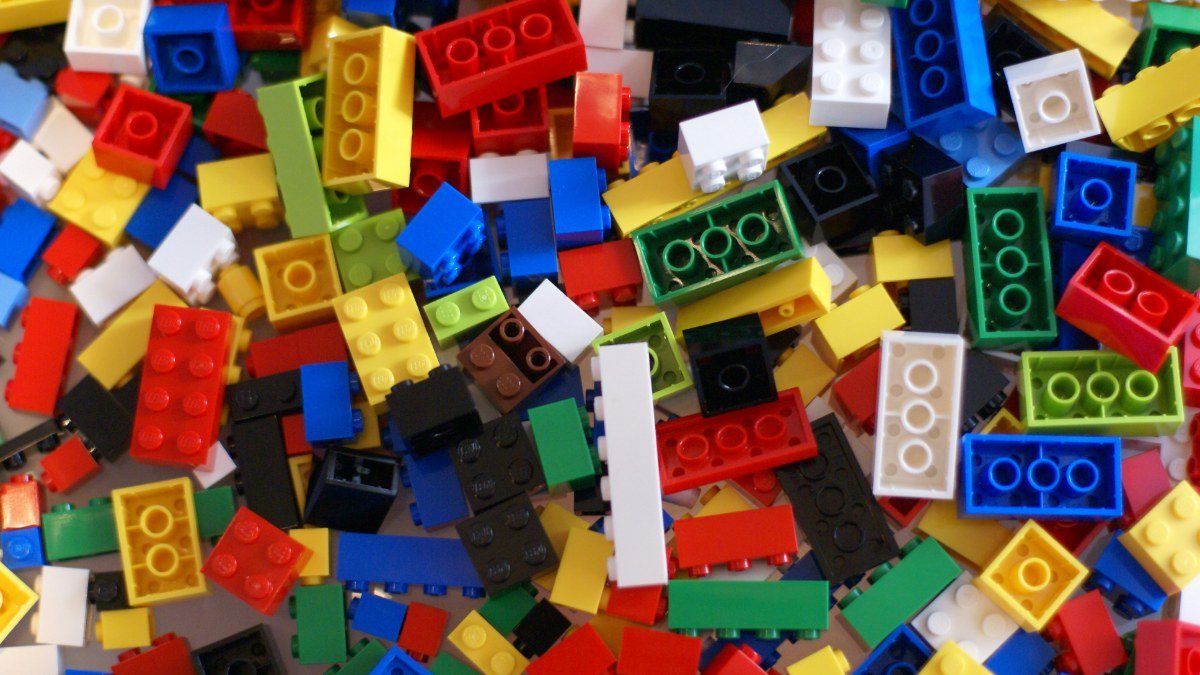 Peças de LEGO de muitas cores e formatos, misturadas sobre uma mesa