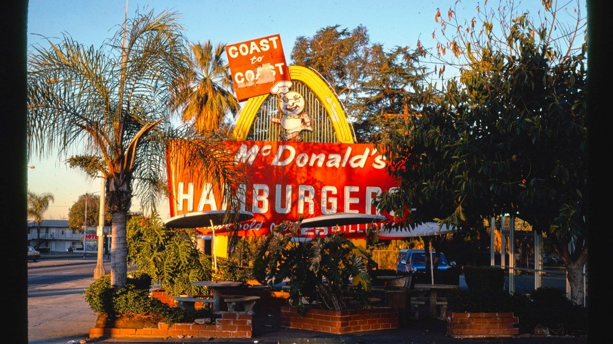 McDonald's no desenho dos anos 1950, com os arcos e a placa do mascote Speedee